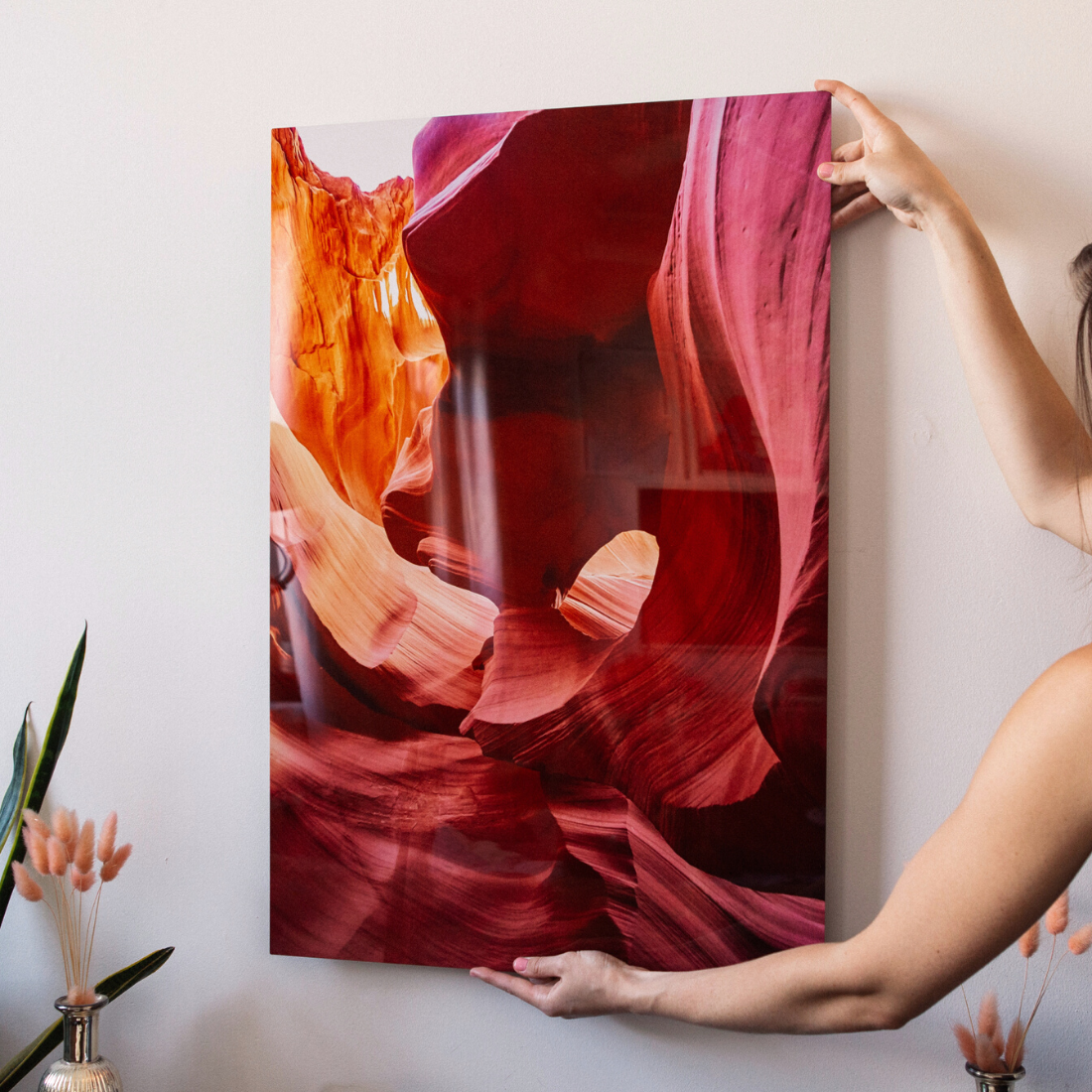 Woman hanging vibrant metal print of Antelope Canyon in modern home decor setting – Aluminyze metal wall art display