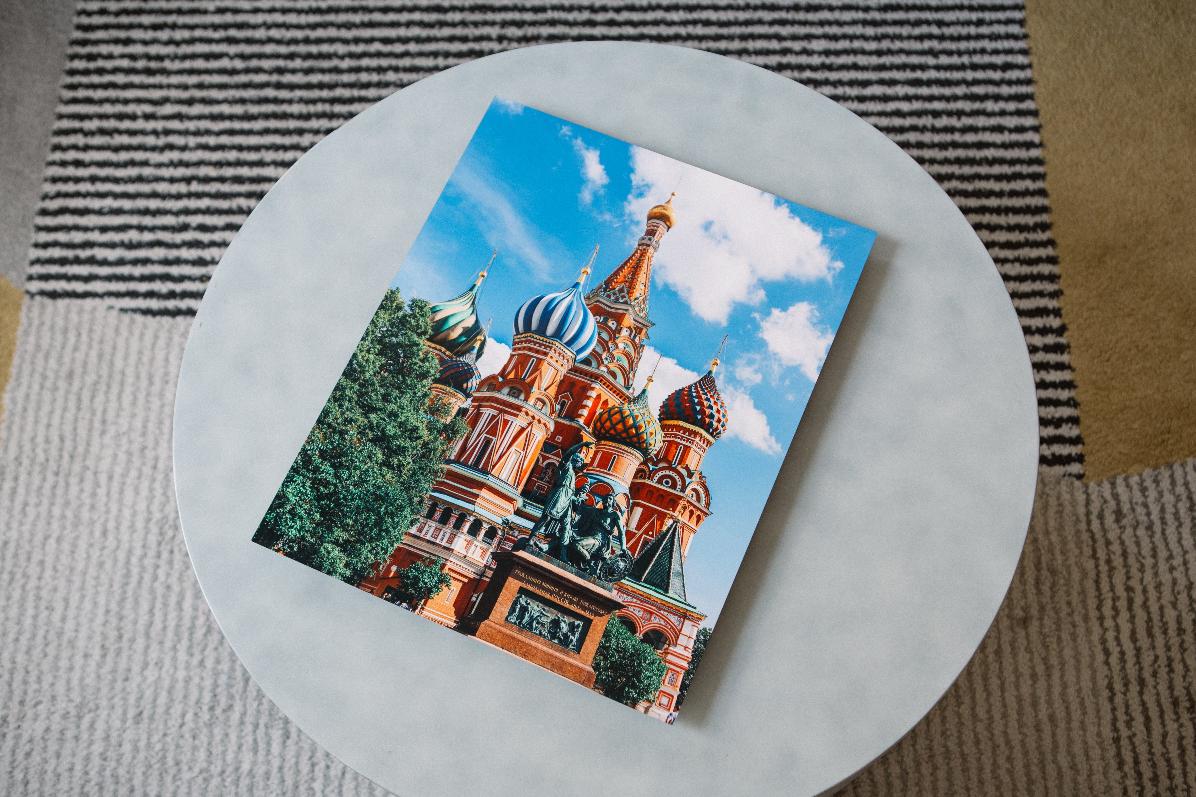Colorful architectural photo print of Saint Basil’s Cathedral displayed on a modern round table, showcasing Aluminyze’s premium aluminum photo print—perfect for custom metal picture prints and home décor.