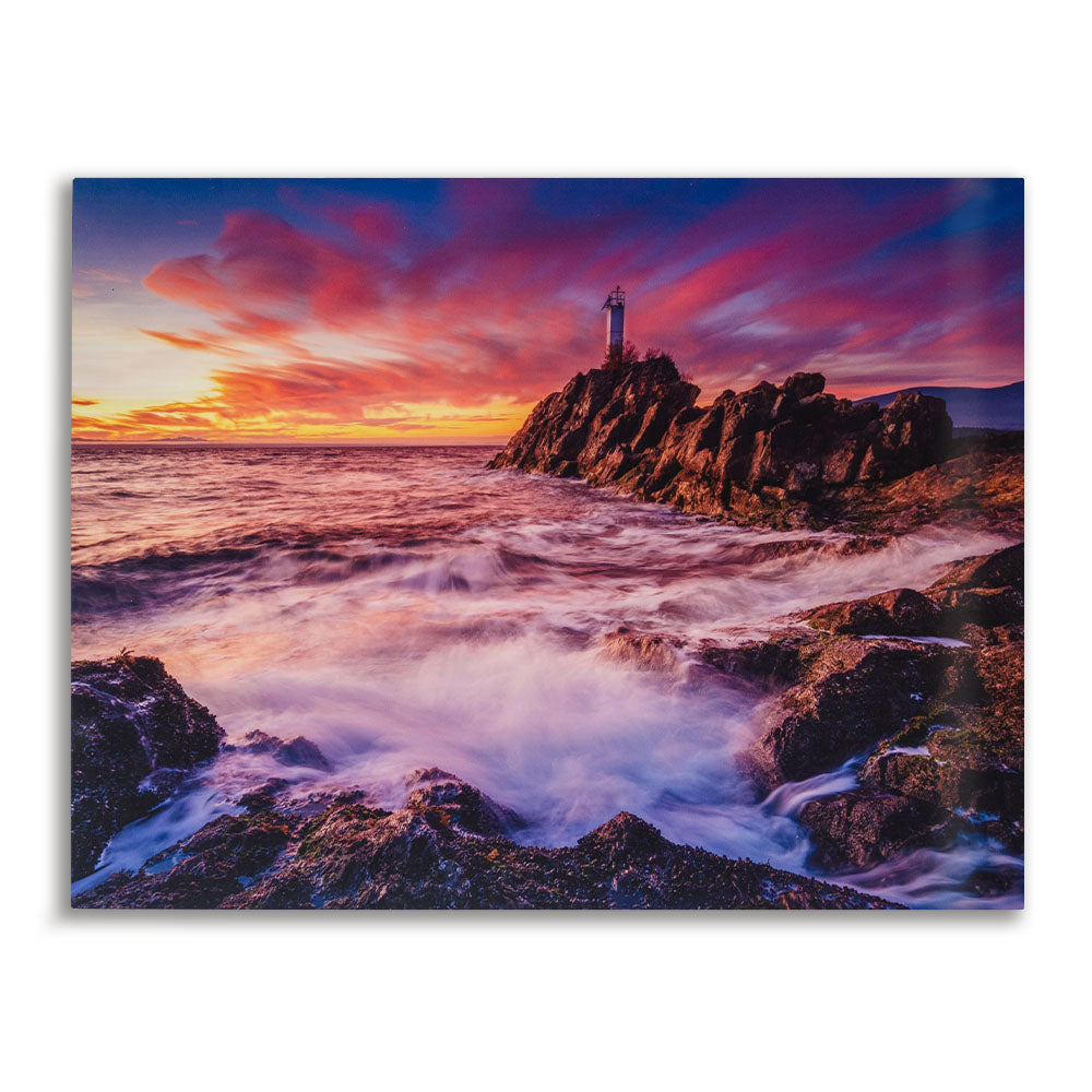 Vibrant ocean sunset metal print featuring a coastal lighthouse and crashing waves, printed on glossy aluminum for modern wall decor in homes, offices, or coastal spaces.